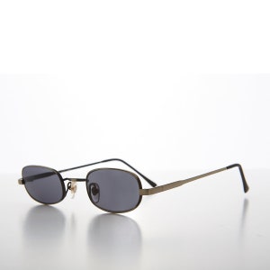 Puede incluir: Un par de gafas de sol rectangulares con montura de metal plateado y lentes grises oscuras.