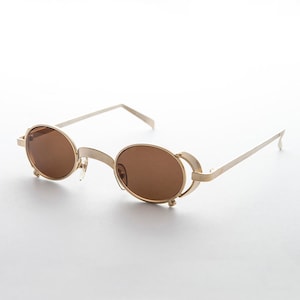 May include: Gold-tone oval sunglasses with brown lenses and a unique, open-frame design.