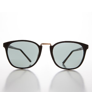 May include: Black round sunglasses with a gold metal bridge and gray lenses.