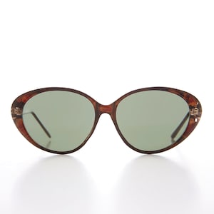 May include: Brown tortoise shell oval sunglasses with green lenses.