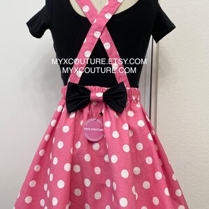 Puede incluir: Una camiseta negra con tirantes rosas y una falda rosa con lunares. Los tirantes son rosas con lunares blancos. Un lazo negro est&aacute; sujeto a la falda. El texto "MYXCOUTURE.ETSY.COM" y "MYXCOUTURE.COM" son visibles.