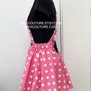 Puede incluir: Falda con peto rosa de lunares blancos, combinada con una camiseta negra. La falda tiene tirantes y un lazo negro. El texto "MYXCOUTURE.ETSY.COM" y "MYXCOUTURE.COM" son visibles.