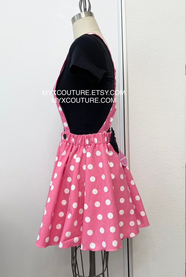 Puede incluir: Falda con peto rosa de lunares blancos, combinada con una camiseta negra. La falda tiene tirantes y un lazo negro. El texto "MYXCOUTURE.ETSY.COM" y "MYXCOUTURE.COM" son visibles.