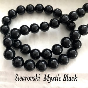 May include: A strand of black Swarovski Mystic Black round beads. The beads are approximately 8mm in diameter.