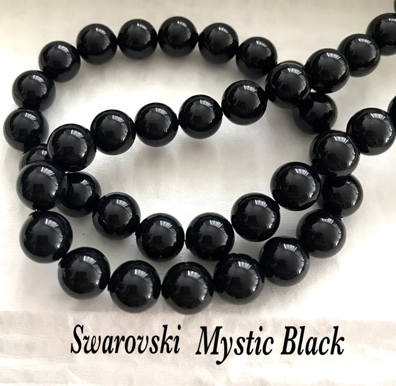 May include: A strand of black Swarovski Mystic Black round beads. The beads are approximately 8mm in diameter.