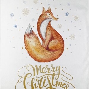 May include: White Christmas-themed kitchen towel featuring a watercolor illustration of a fox with a fluffy tail, surrounded by snowflakes. The words "Merry Christmas" are written in gold script.