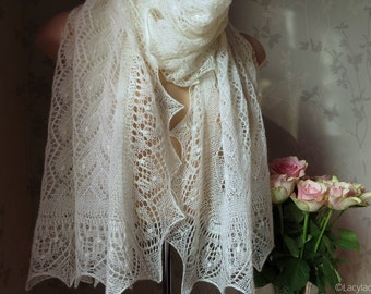 May include: A white lace shawl with a delicate pattern. The shawl is draped over a mannequin and has a flowing, elegant look.