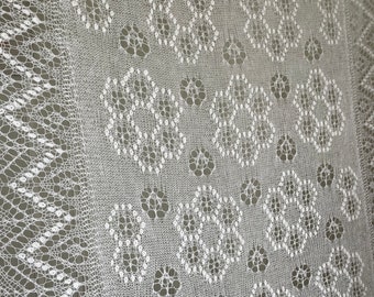 May include: White crocheted shawl with a delicate lace pattern. The shawl has a scalloped edge and a repeating pattern of small circles and hexagons.