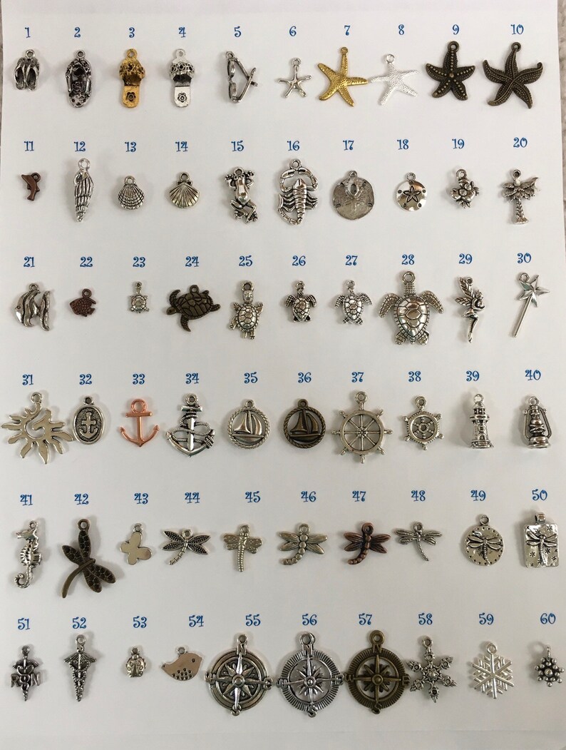 Pu&ograve; includere: Sessanta ciondoli in metallo assortiti con vari temi marini e da spiaggia, tra cui conchiglie, stelle marine, ancore, tartarughe e fari. I ciondoli sono disposti in file su uno sfondo bianco, numerati da 1 a 60.
