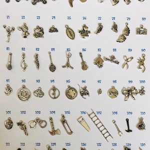 Pu&ograve; includere: Una collezione di 130 ciondoli d'argento, ognuno con un design diverso. I ciondoli sono disposti in file su uno sfondo bianco, numerati da 61 a 130. I ciondoli includono design a tema sportivo, note musicali, simboli religiosi e altro ancora.