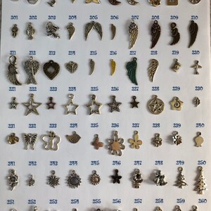 Pu&ograve; includere: Una collezione di 100 ciondoli d'argento, disposti in file su uno sfondo bianco. I ciondoli presentano una variet&agrave; di design, tra cui cuori, stelle, ali, simboli di pace e altro ancora.