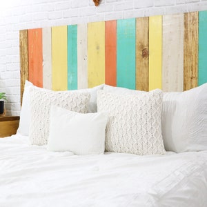 Full size multi-colored boho style wood panel floating headboard with natural brown base wood stain, peach, off-white, yellow and mint hues,  paired with matching floating nightstands in a golden brown finish