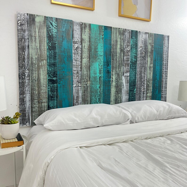 May include: A rectangular headboard constructed from vertical wooden planks featuring a distressed finish in shades of dark grey, teal, and light mint green. The wood grain texture is visible throughout the panels, creating a multi-coloured surface.