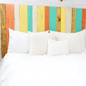 Multicolored twin beach wood headboard with vertical slats in a golden brown, coral, white, yellow and green wood colors, paired with a golden brown wood stain floating nightstands.