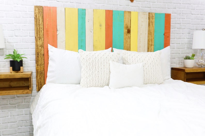 Multicolored twin beach wood headboard with vertical slats in a golden brown, coral, white, yellow and green wood colors, paired with a golden brown wood stain floating nightstands.