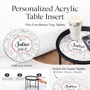 May include: Personalized acrylic table insert with a custom name, designed to fit Five Below tray tables. The insert features a patterned design with the name "Jamie" in a decorative font. Includes a black tray table with a white tumbler and a phone.