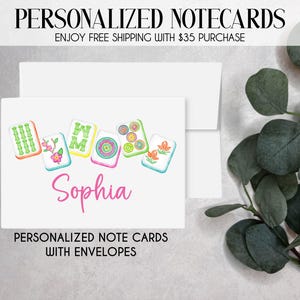 May include: White personalized notecards with envelopes. The cards feature colorful illustrations of Mahjong tiles and the name "Sophia" in pink script. The text "PERSONALIZED NOTECARDS" and "PERSONALIZED NOTE CARDS WITH ENVELOPES" are displayed.
