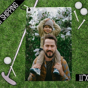May include: A personalized photo print, 11" x 18", featuring a man and child. The image is set on a green lawn with golf balls, tees, and a putter. The words "FAST SHIPPING" are printed on a black banner.