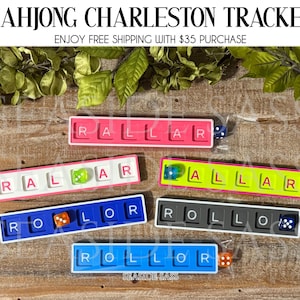 May include: Colorful Mahjong Charleston Tracker sets. Each tracker features a rectangular design with lettered tiles and a die. The trackers come in various colors, including pink, blue, yellow, and gray. The text "MAHJONG CHARLESTON TRACKER" is at the top.