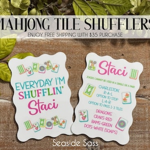 May include: Two white Mahjong tile shufflers with wavy edges. One reads "Everyday I'm Shufflin' Staci" in teal and pink. The other lists game rules and "Staci" in pink. Both feature Mahjong tile illustrations. The text "Mahjong Tile Shufflers" is at the top.