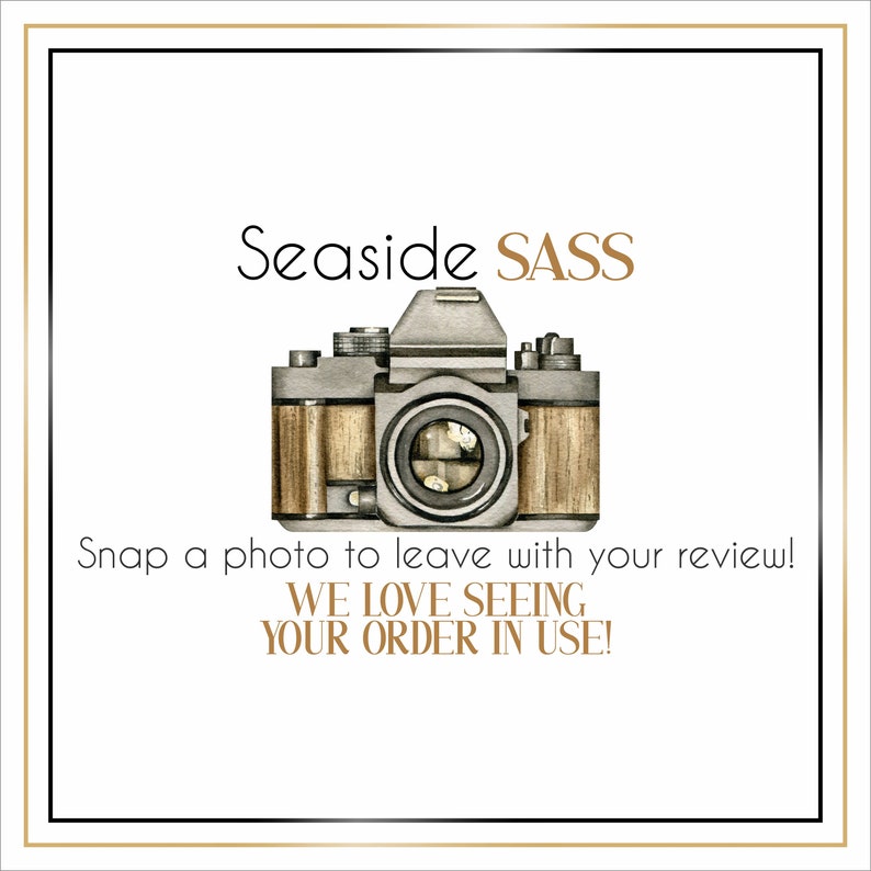 May include: A white card with a black border and gold text that says "Seaside SASS". A vintage camera with a brown leather case is in the center of the card. The text below the camera says "Snap a photo to leave with your review! WE LOVE SEEING YOUR ORDER IN USE!"