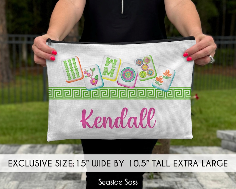 May include: White canvas zippered pouch with a green, white, and red Chinese Mahjong tile design. The pouch is 15 inches wide by 10.5 inches tall and has the name "Kendall" printed in pink.