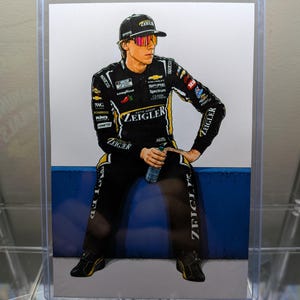 May include: A digital illustration of a race car driver wearing a black and yellow racing suit with various sponsor logos, including Zeigler Auto Group. The driver wears a black cap, reflective sunglasses, and holds a clear water bottle while sitting.