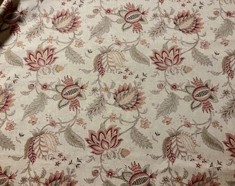 May include: A beige fabric with a repeating floral pattern. The flowers are red, green, and brown. The fabric has a subtle texture.