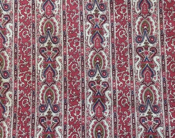 以下が含まれることがあります： 赤と白のペイズリー柄の生地で、繰り返し模様が施されています。生地はビンテージな見た目と感触です。