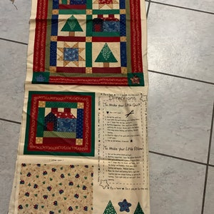 May include: A fabric panel with instructions for making a quilt and pillow. The panel features a red, green, and blue patchwork design with houses, stars, and trees. The instructions include "Directions to Make Your Little Quilt!" and "To Make Your Little Pillow!"