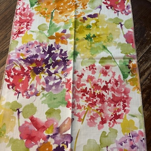 May include: A fabric swatch with a watercolor floral pattern in shades of pink, purple, yellow, and orange. The fabric has a white background and the text "TRENHOLME SUMMER" is visible.
