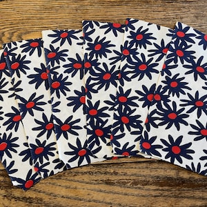 May include: Six fabric squares with a white background and a repeating pattern of dark blue stylized flowers with red centers.
