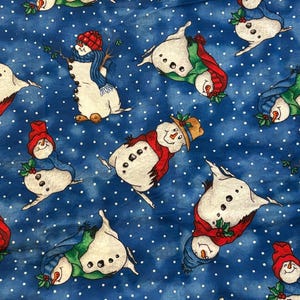 May include: A blue fabric with a repeating pattern of snowmen. The snowmen are white with black button eyes and noses, wearing red hats and scarves. The background is a blue speckled pattern.