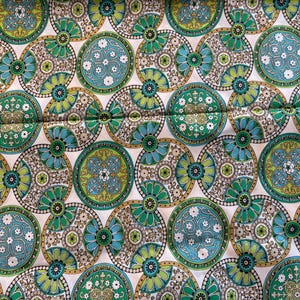 May include: A white ceramic mug with a black handle and the text "But First, Coffee" in a bold, black font. The mug is set against a blurred background, highlighting its clean design.