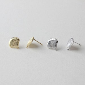Può includere: Tre paia di chiusure per orecchini a forma di conchiglia in finiture oro, argento e rodio. Le chiusure hanno un anello in basso per attaccare un orecchino pendente.