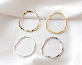 May include: Four simple, minimalist rings in two different finishes. Two gold rings and two silver rings are shown on a white background.