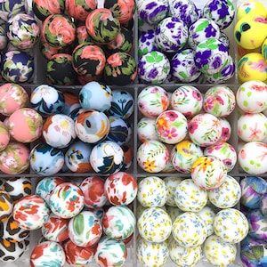 May include: Assortment of colourful silicone beads with floral and animal print designs. The beads are arranged in ten separate containers.
