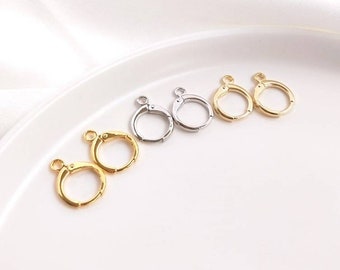 May include: Four pairs of gold and silver earring hooks. The hooks are made of metal and have a spring-loaded clasp.