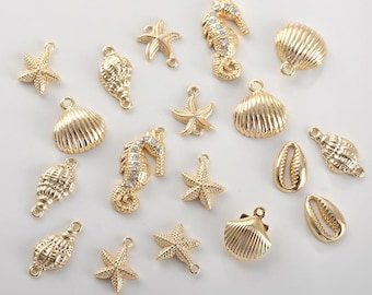 May include: A collection of gold-colored charms in various shapes, including starfish, seashells, seahorses, and scallop shells. Some seahorse charms are embellished with clear rhinestones. Each charm has a small loop for attaching to jewelry or other crafts.