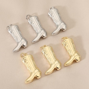 May include: Six metal cowboy boot charms in silver and gold. The charms have detailed embossed designs and small loops for attaching to jewelry or other crafts. The boots have a classic western style with a pointed toe and a small heel.