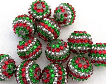 May include: A collection of sparkling, round beads. Each bead is covered in red, green, and silver rhinestones. The beads are clustered together, creating a festive and decorative appearance, perfect for jewelry making or holiday crafts.
