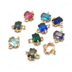 May include: Assortment of ten gold-toned connector charms with faceted glass stones in various colors, including red, blue, green, purple, and clear.