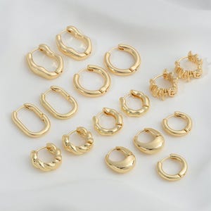 May include: A set of 14 gold hoop earrings in various shapes and sizes. The earrings are made of metal and have a polished finish.