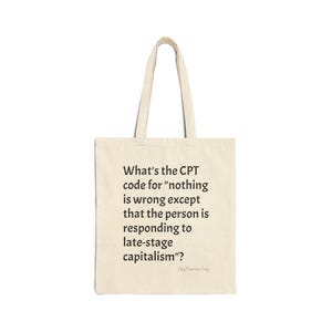 May include: A beige canvas tote bag with two shoulder straps. The front features black printed text that reads: What's the CPT code for "nothing is wrong except that the person is responding to late-stage capitalism"? Below this is smaller text.