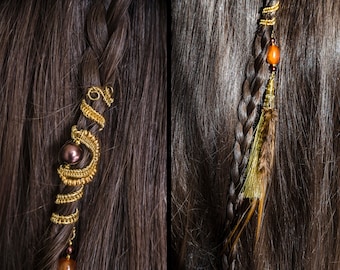 May include: Two braids of brown hair with gold and brown hair accessories. One braid has a gold wire hair accessory with a brown bead. The other braid has a gold and brown feather hair accessory with a brown bead.