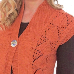 May include: A sleeveless knitted vest in a burnt orange color with a button closure and a lacy pattern on the shoulders.