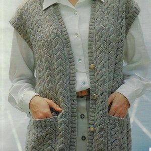 May include: A gray knitted sleeveless vest with a cable knit pattern and two pockets. The vest has a V-neck and is buttoned up the front.