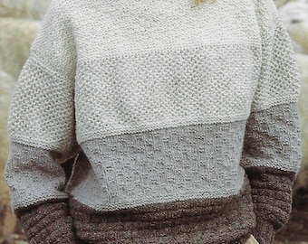 May include: A white, grey, and brown knitted jumper with a boat neck and long sleeves.