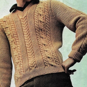 Może przedstawiać: Brązowy sweter z dzianiny kabłąkowej z dekoltem w kształcie litery V.