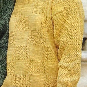 May include: A yellow knitted sweater with a cable knit pattern. The sweater has a round neckline and long sleeves.